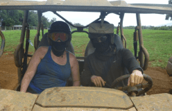 Couple driving an ATV (covered in mud)